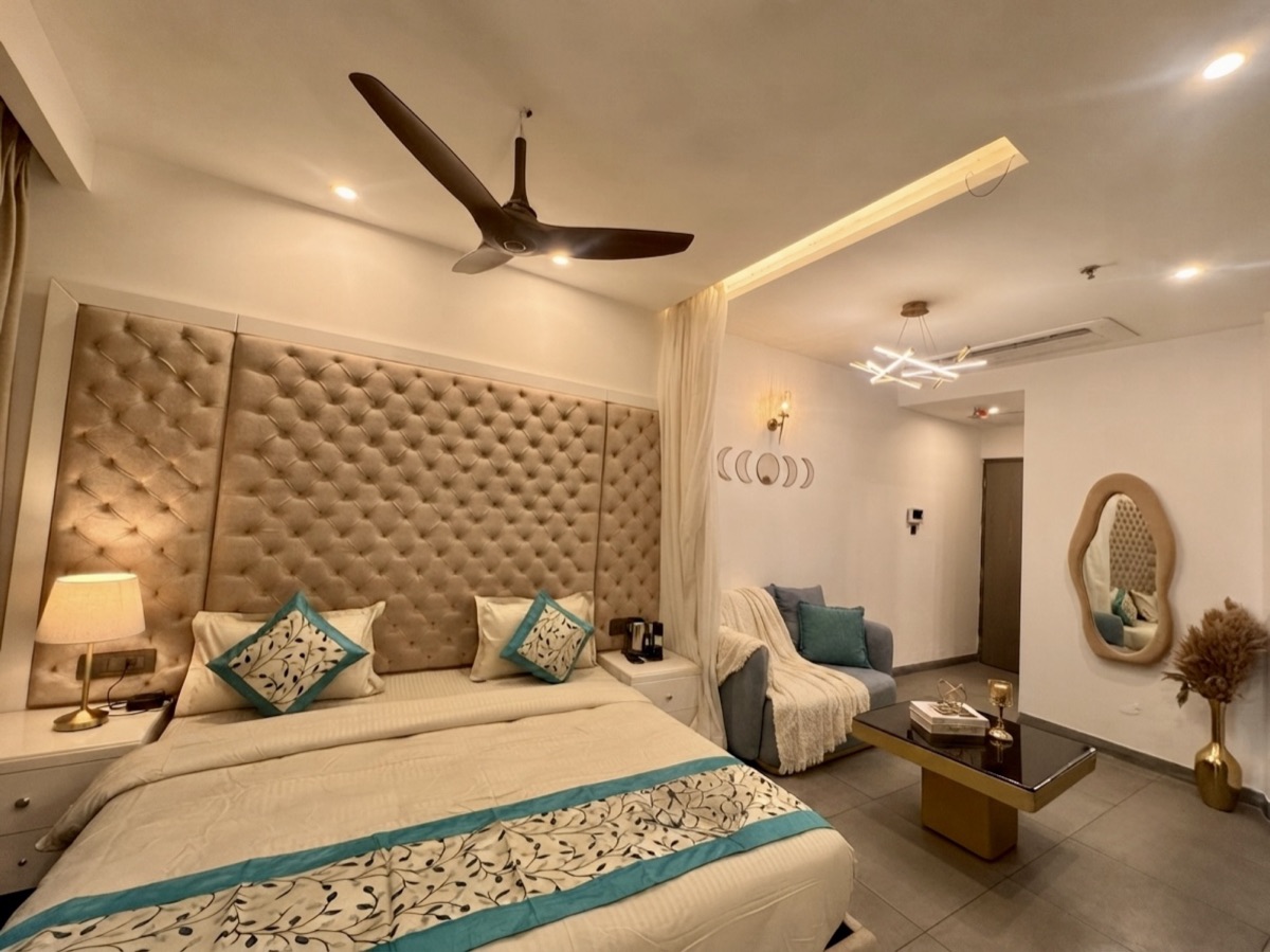 Open-plan studio bedroom with teal accents and a seating nook